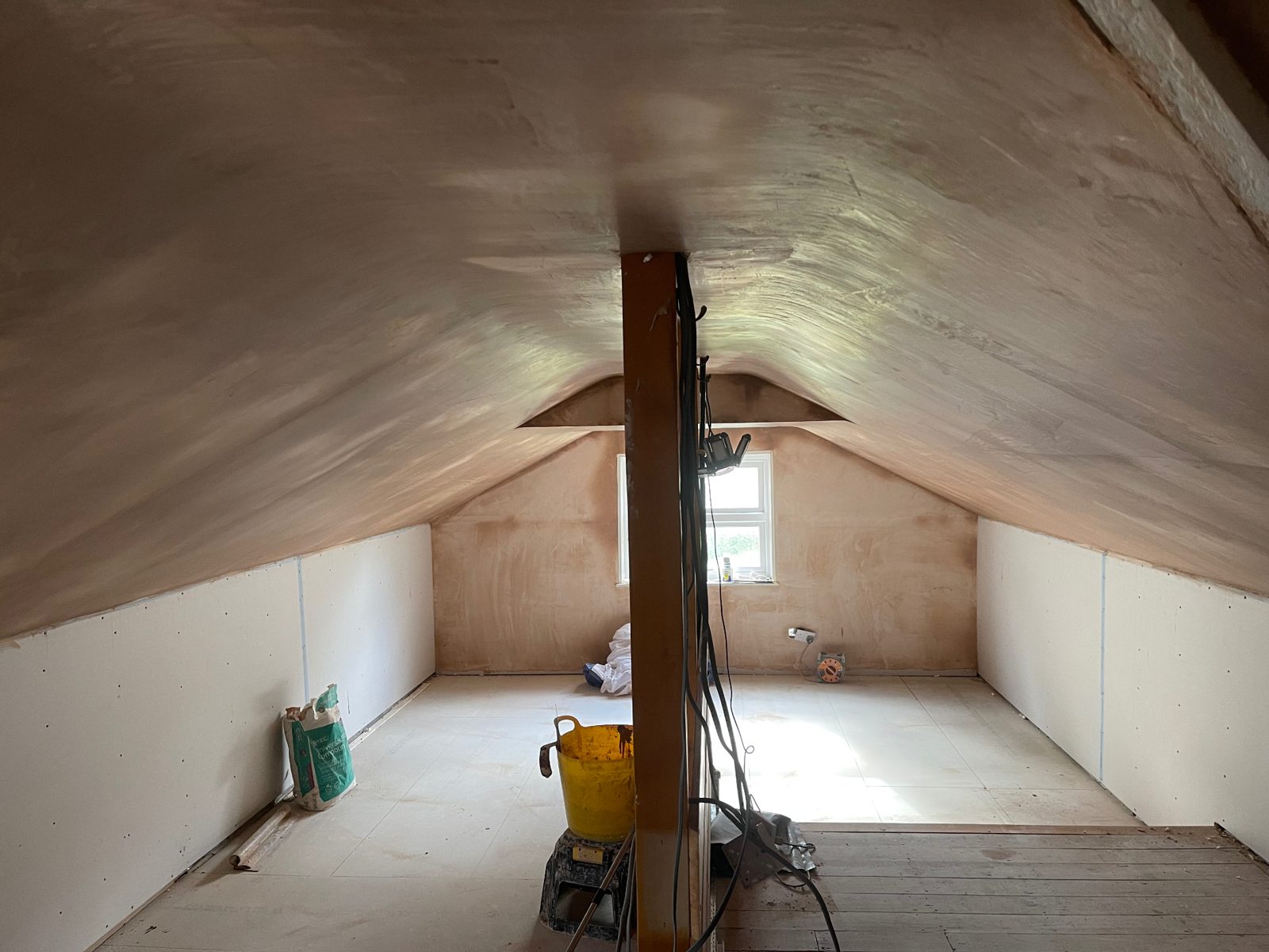 Vaulted loft room with the walls and sloping ceilings freshly plastered
